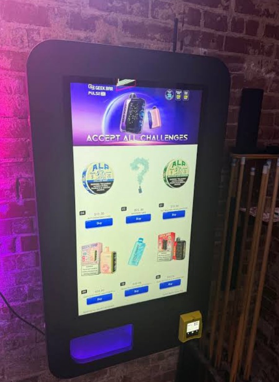 Wall-mounted nightlife essentials vending machine displayed in a stylish bar with neon lighting